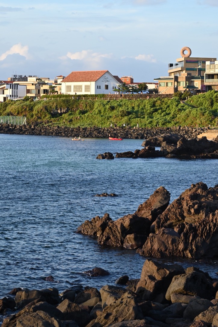 Rocky coast and waterfront buildings in warm sunlight