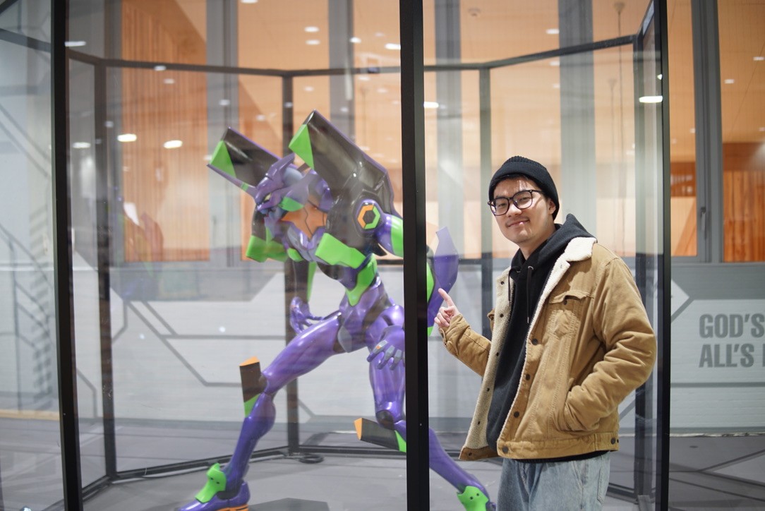 Zack beside an Evangelion Unit-01 display